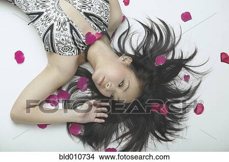 Asian woman laying on floor with rose petals View Large Photo Image Picture - Asian woman laying on floor with rose petals. Fotosearch