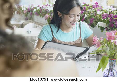 Asian woman with menu at restaurant View Large Photo Image Stock Image - Asian woman with menu at restaurant. Fotosearch