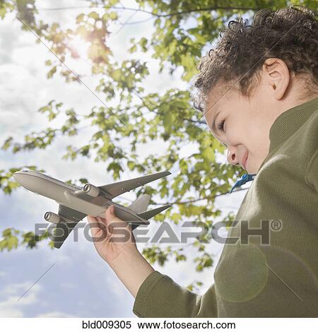 Boy standing outside with toy plane View Large Photo Image Stock Photography - Boy standing outside with toy plane. Fotosearch