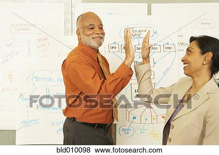 Businessman and women giving high five View Large Photo Image Stock Photo - Businessman and women giving high five. Fotosearch