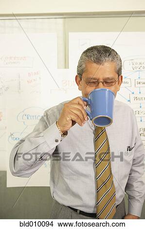 Businessman drinking from coffee cup View Large Photo Image Picture - Businessman drinking from coffee cup. Fotosearch