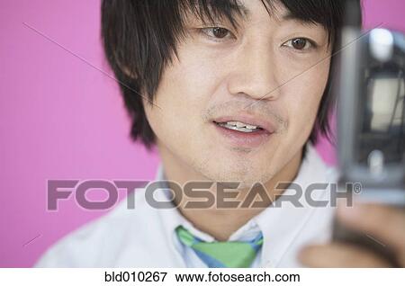 Stock Photo - Businessman holding a mobile phone. Fotosearch