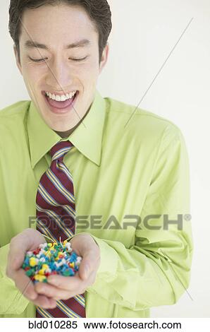 Stock Photography - Businessman with handful of push pins. Fotosearch