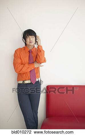 Stock Image - Businessman with headphones listening to music. Fotosearch