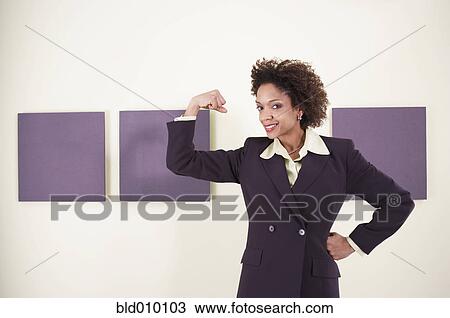 Stock Image - Businesswoman flexing her bicep. Fotosearch