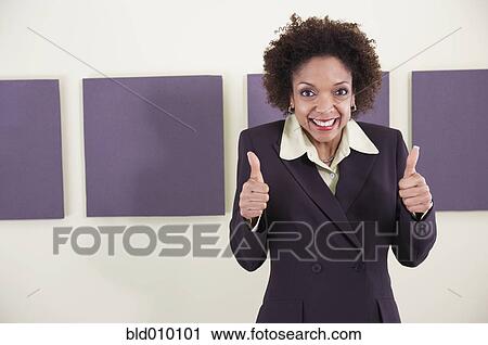 Stock Image - Businesswoman giving thumbs up sign. Fotosearch