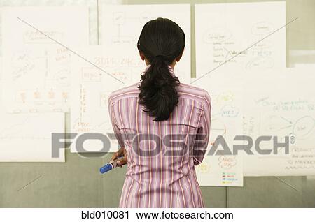 Stock Image - Businesswoman looking at charts. Fotosearch