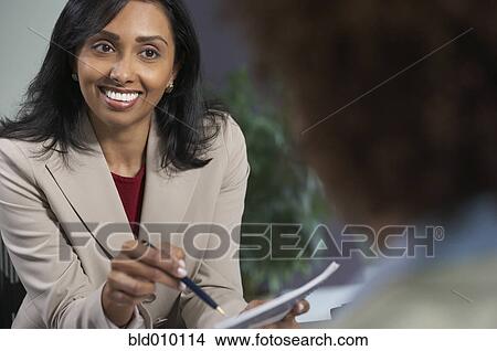 Picture - Businesswoman talking to a colleague. Fotosearch