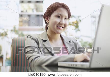 Businesswoman working on a laptop View Large Photo Image Stock Image - Businesswoman working on a laptop. Fotosearch
