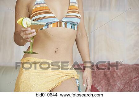 Picture - Close up of woman holding martini glass. Fotosearch