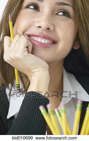 Stock Photo - Close up of woman holding pencil. Fotosearch
