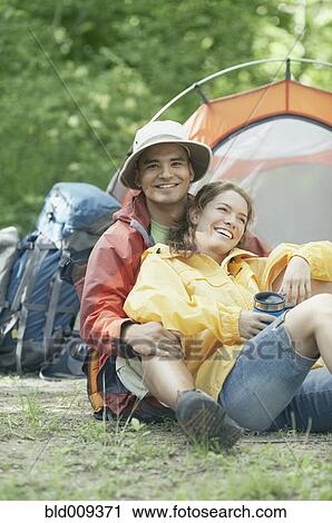 Stock Image - Couple embracing at their campsite. Fotosearch