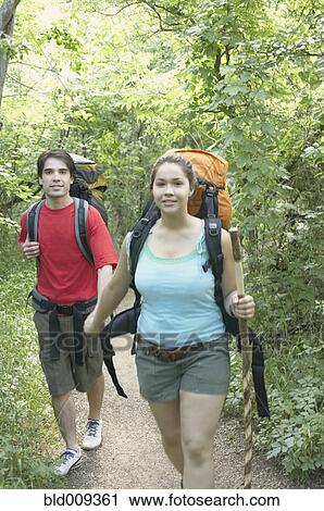 Couple hiking in a forest View Large Photo Image Stock Image - Couple hiking in a forest. Fotosearch