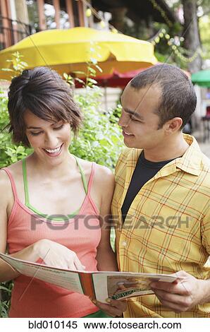 Couple holding restaurant menu View Large Photo Image Stock Photography - Couple holding restaurant menu. Fotosearch
