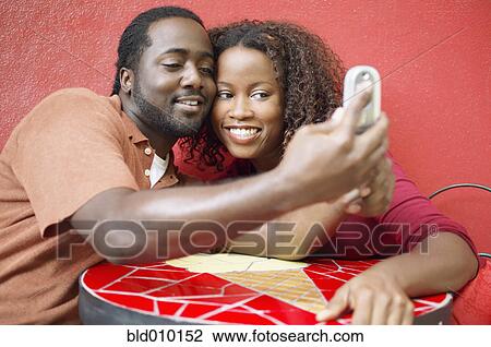 Stock Image - Couple photographing themselves. Fotosearch