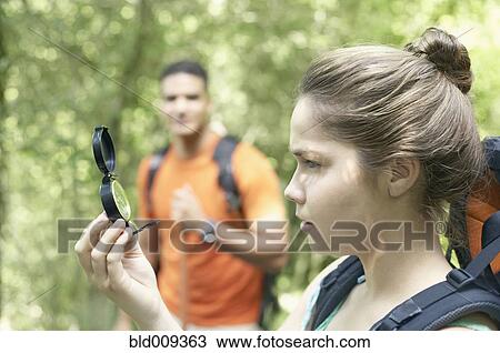 Stock Image - Female hiker using a compass. Fotosearch