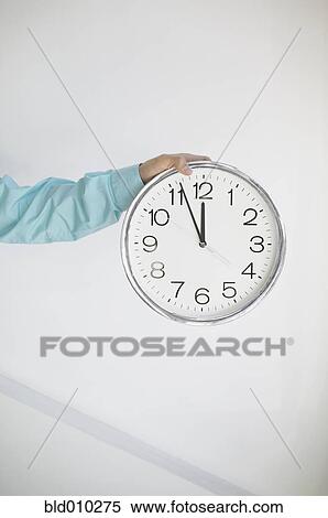 Stock Photography - Hand holding a clock. Fotosearch
