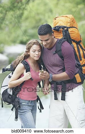 Hiking couple consulting a compass View Large Photo Image Stock Image - Hiking couple consulting a compass. Fotosearch