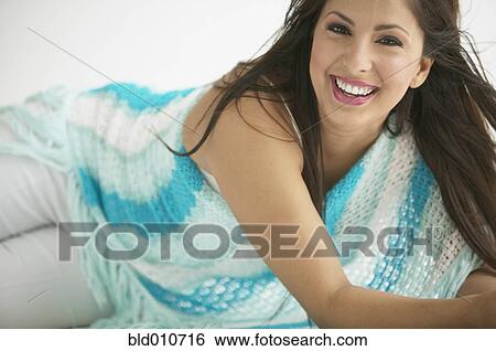 Stock Photograph - Hispanic woman laying on floor smiling. Fotosearch