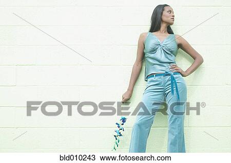 Stock Image - Looking up at a woman holding a flower. Fotosearch