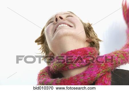 Low angle view of a young woman smiling View Large Photo Image Stock Image - Low angle view of a young woman smiling. Fotosearch
