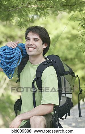 Stock Photo - Man holding a bundle of climbing rope. Fotosearch