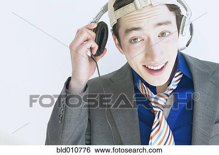Man wearing headphones and listening to music View Large Photo Image Stock Photograph - Man wearing headphones and listening to music. Fotosearch