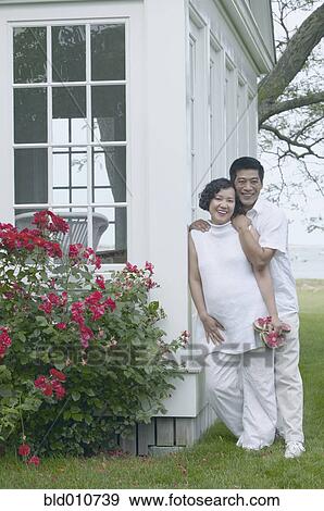 Middle-aged Asian couple leaning exterior of house View Large Photo Image Stock Photo - Middle-aged Asian couple leaning exterior of house. Fotosearch