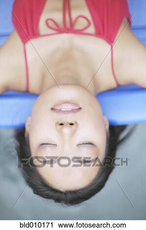 Stock Image - Overhead view of a relaxed young woman. Fotosearch