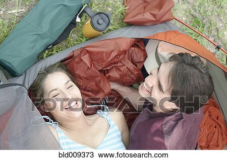 Stock Image - Overhead view of young couple in a tent. Fotosearch
