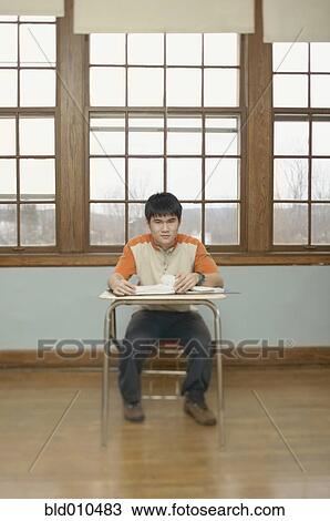 Stock Image - Portrait of a teenage boy in a classroom. Fotosearch