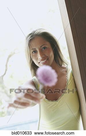 Portrait of a young woman holding a flower View Large Photo Image Stock Image - Portrait of a young woman holding a flower. Fotosearch
