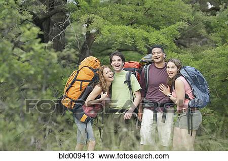 Stock Image - Portrait of two young couples hiking in a forest. Fotosearch