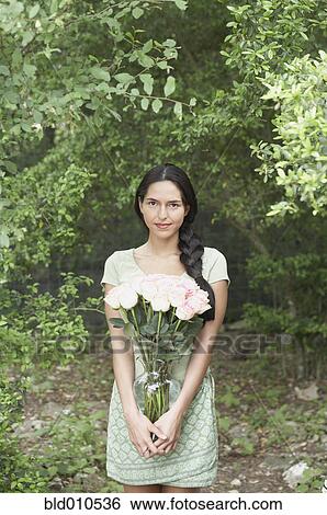 Portrait of woman holding flower arrangement View Large Photo Image Stock Photograph - Portrait of woman holding flower arrangement. Fotosearch