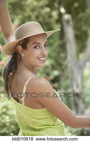 Stock Photo - Portrait of woman wearing straw hat. Fotosearch