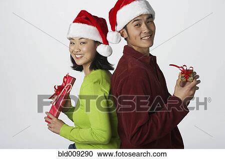 Stock Image - Portrait of young couple with gifts. Fotosearch