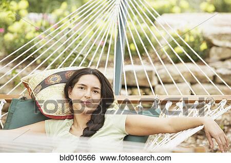 Portrait of young woman lying on hammock View Large Photo Image Stock Photograph - Portrait of young woman lying on hammock. Fotosearch