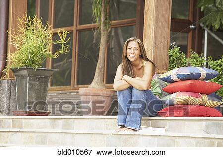 Stock Photo - Portrait of young woman on steps. Fotosearch