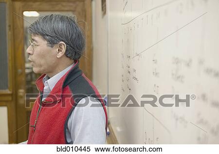 Stock Photography - Profile of male teacher at whiteboard. Fotosearch