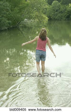 Rear view of woman walking in water View Large Photo Image Stock Photography - Rear view of woman walking in water. Fotosearch