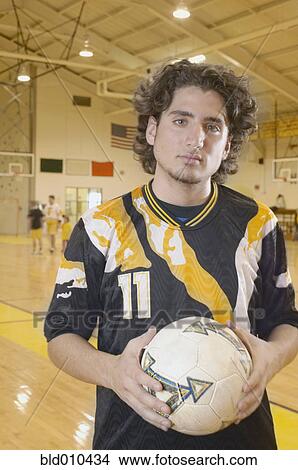 Picture - Teenage boy holding soccer ball. Fotosearch