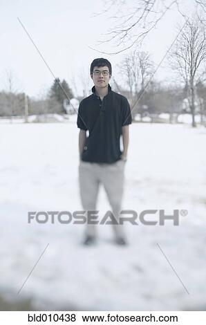 Stock Photo - Teenage boy standing in snow. Fotosearch