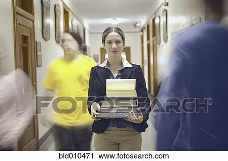 Stock Image - Teenage girl carrying books. Fotosearch