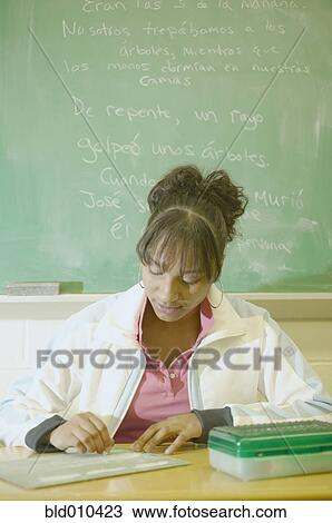 Stock Image - Teenage girl sitting in a classroom. Fotosearch