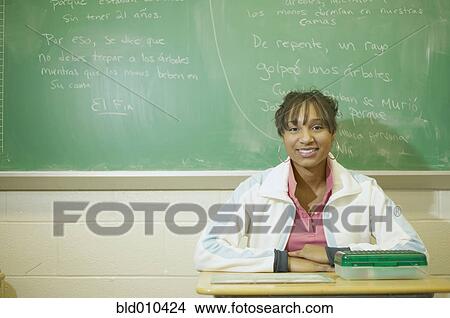 Picture - Teenage girl sitting in classroom. Fotosearch