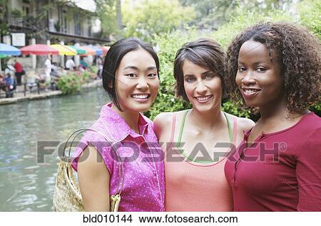 Three female friends standing outside View Large Photo Image Picture - Three female friends standing outside. Fotosearch