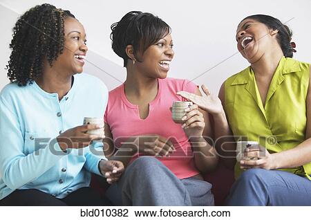 Stock Image - Three women together laughing. Fotosearch