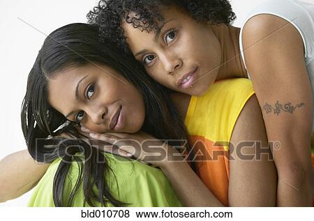 Stock Photo - Two African American women hugging and smiling. Fotosearch
