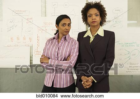 Picture - Two businesswomen standing together. Fotosearch