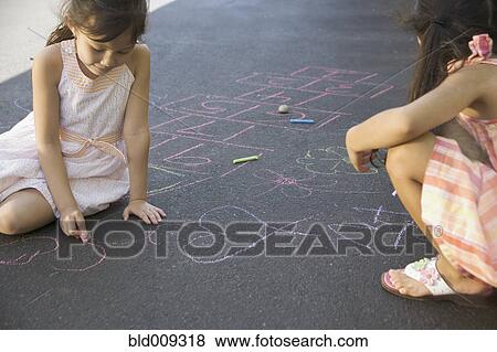 Two girls making chalk drawings View Large Photo Image Stock Photo - Two girls making chalk drawings. Fotosearch